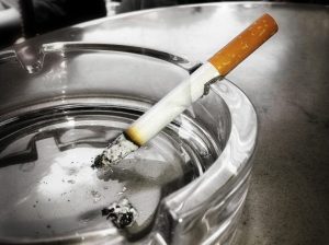 stock image of a cigarette on an ash tray for a blog about how smoking affects your teeth in Charlotte, NC