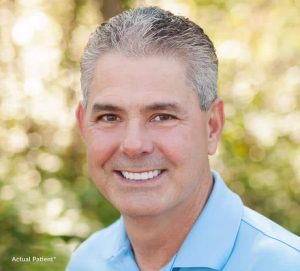 stock image of a man smiling for blog about how genetics affect dental treatments in Charlotte